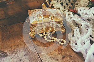 A beautiful antique golden jewelry box with natural white pearls on wooden table