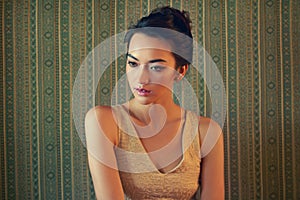 Beautiful in any style. a beautiful young woman dressed elegantly in a green wallpapered room.