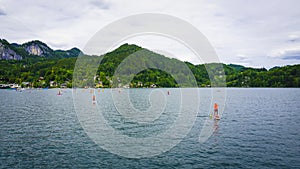 Beautiful Aps landscape with big lake surrounded by green mountains, sailing people photo