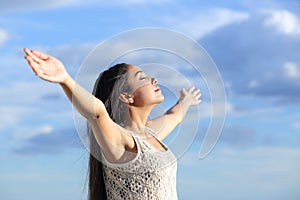 Beautiful arab woman breathing fresh air with raised arms photo
