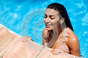 Beautiful Arab woman relaxing in swimming pool.