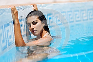 Beautiful Arab woman relaxing in swimming pool.