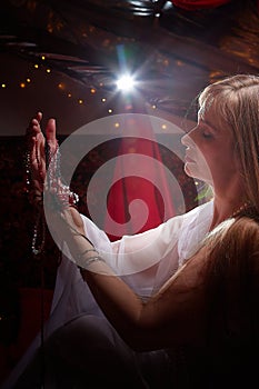 Beautiful arabian girl with candles in red room full of rich fabrics and carpets in sultan harem. Photo shoot of woman