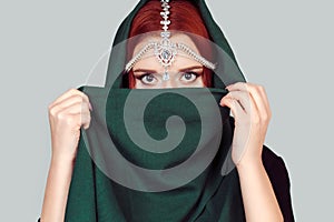 Beautiful Arabian style girl portrait. Portrait of beauty Indian model with bright make-up who is hiding, cover her face behind