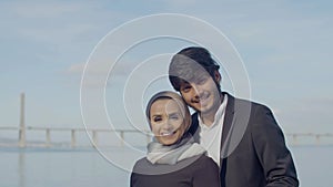 Beautiful Arabic couple standing in background of blue sky