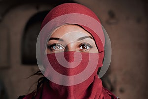 Beautiful arabic woman in red hijab with bright makeup