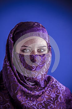 Beautiful arabic woman with traditional veil on her face, intens