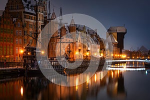 Beautiful architecture of the old town in Gdansk by the MotÅ‚awa river with a historic port crane at wintery night. Poland