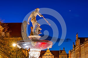 Beautiful architecture of the old town in Gdansk with Neptune fountain at night, Poland