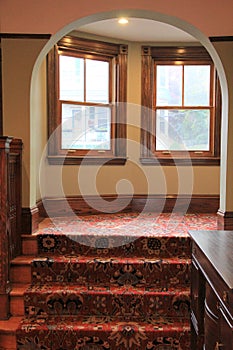 Beautiful archway, with warm wood and carpeting in home