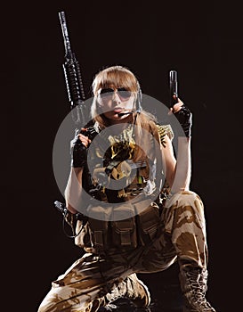 Beautiful army girl with gun isolated on the black background