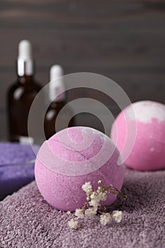 Beautiful aromatic bath bomb and gypsophila flowers on soft towel, closeup. Space for text