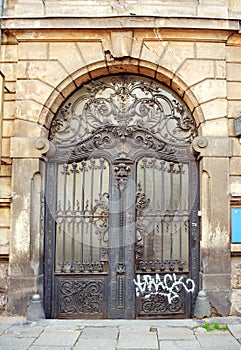 Beautiful art nouveau door gate with ugly graffiti