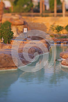 Beautiful artificial lake among the stones in the hotel complex at sunset in summer