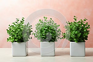 Beautiful artificial plants in flower pots on marble table against color background