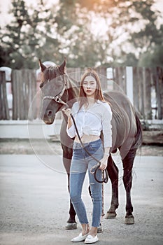 Beautiful Asia girl taking care of her horse with love and caring