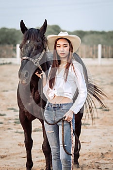Beautiful Asia girl taking care of her horse with love and caring