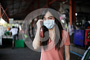 Beautiful asia woman wearing mouth mask against air smog pollution PM 2.5 and Coronavirus in the community,bangkok thailand