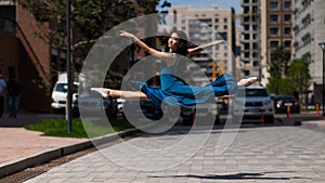 Beautiful Asian ballerina dancing outdoors. Urban landscape. Grand jete.