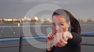 A beautiful Asian brunette girl beats a boxing deuce in front of the camera. Close-up. Sport. Box