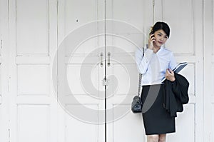 Beautiful Asian business woman calling mobile phone.