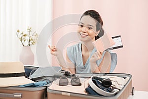 Beautiful Asian business woman smiling holding passport and ticket with yellow suitcase to prepare traveling for travel tourist on