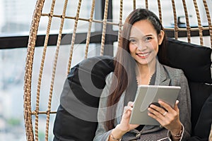 Beautiful asian business woman using tablet working in office and smiling