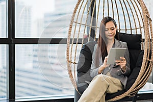 Beautiful asian business woman using tablet working in office and smiling