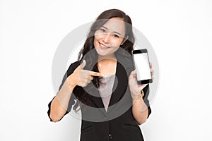 Beautiful Asian business woman wearing black suit hand holding a smartphone and pointing presenting something on white background