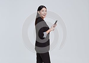 Beautiful Asian businesswoman using mobile phone and happy celebration isolated on white studio background