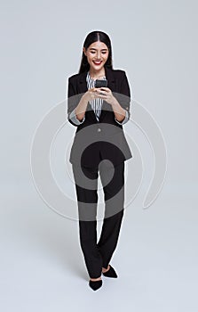 Beautiful Asian businesswoman using mobile phone and happy celebration isolated on white studio background