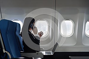 Beautiful Asian businesswoman working with laptop in aeroplane. working, travel, business concept