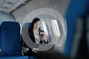 Beautiful Asian businesswoman working with laptop in aeroplane. working, travel, business concept