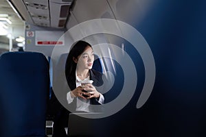 Beautiful Asian businesswoman working with laptop and mobile in aeroplane. working, travel, business concept