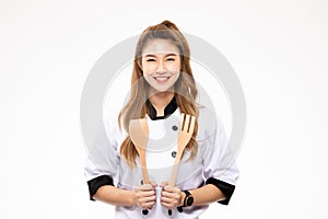 Beautiful Asian chef woman smile and holding wooden Spatula and fork isolated on white background