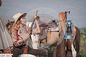 Beautiful Asian cowboy who takes care of her gun and horse with love while at the camp