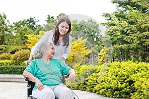 Beautiful Asian daughter takes care of elderly mother in the park.