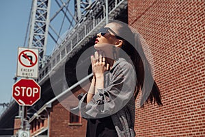 Beautiful asian fashion model girl posing on city street wearing stylish denim clothes and sunglasses