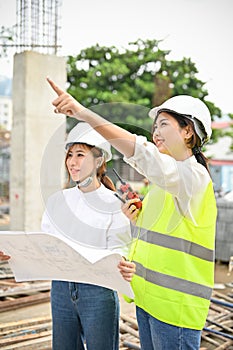 Beautiful Asian female engineer and female architect at the construction site