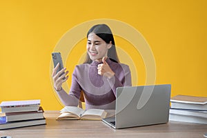 A beautiful Asian female is showing her thumb up while talking on a video call