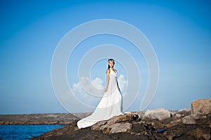 Beautiful Asian girl dressed in white dress enjoying sea breeze by the sea