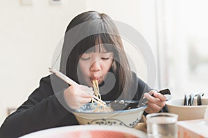 Asian girl eating chashu ramen in japanese restaurant