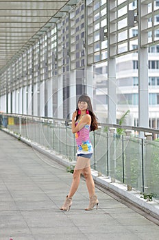 Beautiful Asian girl showing youthful vigor on the pedestrian bridge