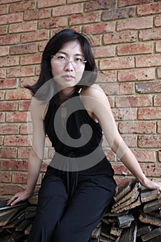 Beautiful Asian girl sitting down and looking at the viewer