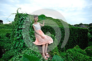 Beautiful Asian girl strolls in the plant wall photo
