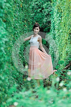 Beautiful Asian girl strolls in the plant wall photo