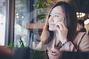 A beautiful Asian girl talking on smart phone with smiley face