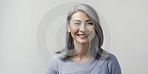 Beautiful asian with grey hair smiling standing near the wall