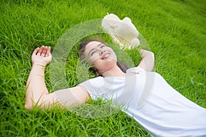 Gril lying on freash green grass field and smiles photo