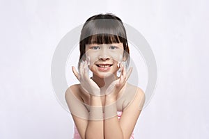 Beautiful Asian gym girl laughing applying face cream with clean fresh skin on white background.